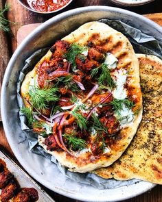 two pita breads with onions and herbs on top