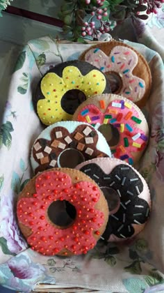 there are many donuts in the box on the table and one is decorated with sprinkles