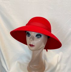 This classic style red 100% wool felt hand blocked lampshade style hat has a 4-inch brim and is trimmed with a red grosgrain ribbon band around the brim. The hat will fit up to a 22 5/8 inch head size and is perfect for winter weather. NOTE: Please check the head size before purchase, I am happy to answer any questions you may have. There will be a 20% restocking fee for all returned hats. Adjustable Brimmed Wool Cloche Hat, Adjustable Wool Brimmed Cloche Hat, Classic Adjustable Felt Cloche Hat, Adjustable Felt Cloche Hat In Classic Style, Adjustable Wide Brim Felt Cloche Hat, Adjustable Classic Felt Cloche Hat, Adjustable Wool Cloche Hat With Flat Brim, Red Brimmed Felt Hat For Winter, Adjustable Wool Cloche Felt Hat