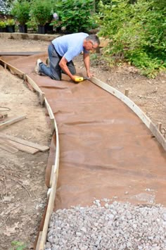 a man is laying concrete on the ground