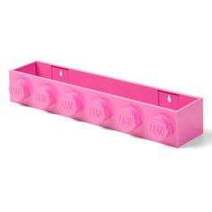 a pink plastic shelf with four knobs on each side and three holes in the middle