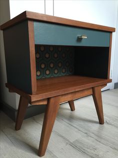 a small wooden table with a drawer on one side and a shelf on the other