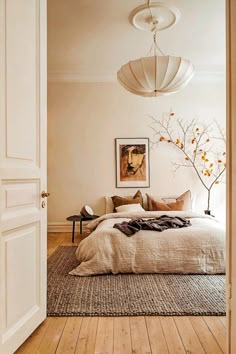 a bedroom with a large bed sitting next to a doorway and a painting on the wall