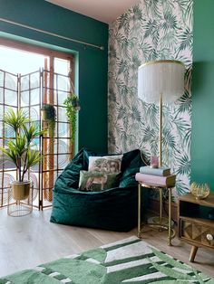 a living room with green walls and palm leaves on the wall, including a bean bag chair