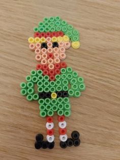 an image of a person made out of legos on a wooden table with beads