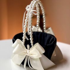 a black and white purse with pearls on the handle is sitting on top of a table