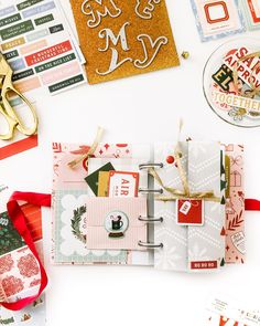 the contents of a christmas scrapbook are laid out on a table with scissors and other items