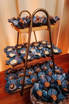 blue flowers are stacked on top of an old wooden stand with metal bars to hold them