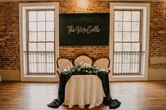 the table is set up in front of two windows and a sign that says, the mill falls