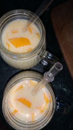 two glass jars filled with food sitting on top of a black counter next to each other