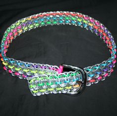 a multicolored beaded dog collar with a metal buckle on a black background