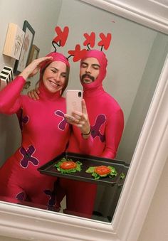 a man and woman in pink costumes taking a selfie