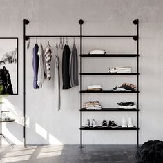 an open closet with clothes and shoes hanging on the wall