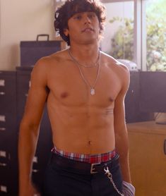 a shirtless young man standing in an office