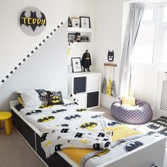 a bed room with a neatly made bed and batman decorations