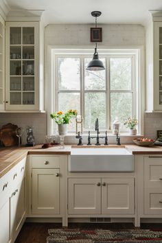 Elegant modern country farmhouse kitchen with cream cabinets and vintage accessories Picture Window Over Kitchen Sink, Large Kitchen Sink Window, Timeless Farmhouse Kitchen, Modern Country Kitchen Farmhouse, Kitchen Window Farmhouse, Cream Farmhouse Kitchen, Low Country Kitchen, Farmers Sink Kitchen, Wooden Kitchen Countertops