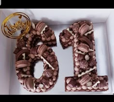 a cake in the shape of the number ten is decorated with nuts and chocolates