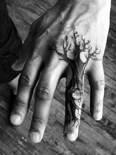 a person's hand with a tree tattoo on it