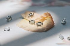 some diamonds are laying on top of a piece of paper that has been cut into pieces