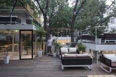 an outdoor living area with couches, tables and stairs leading up to the second floor