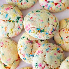 colorful sprinkle cookies are arranged on a white surface