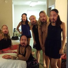 a group of people standing around a bed in a room