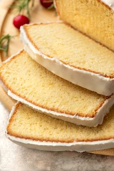 slices of pound cake sitting on top of a wooden platter with holly sprigs