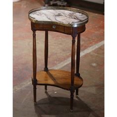 a marble topped end table sitting on top of a floor