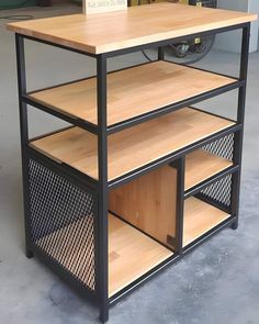 a wooden table with metal frame and shelves on the bottom, sitting in a garage