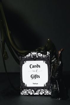 a sign that says cards and gifts with an elephant statue in the foreground, against a dark background