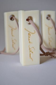 three soap bars with writing on them tied to each other, sitting next to each other