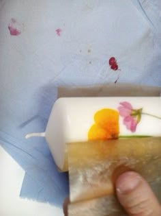 a person holding a piece of cake with flowers on it