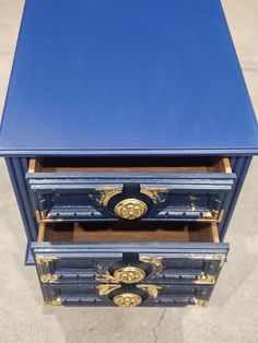 three drawers are stacked on top of each other with gold trimmings and blue paint