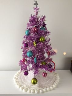 a purple christmas tree with ornaments on it