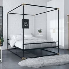 a bedroom with a white bed and black metal frame