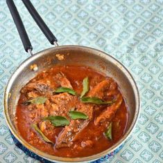 a bowl filled with meat and sauce on top of a table next to chopsticks