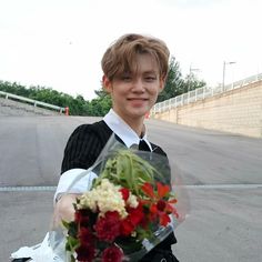 a young man holding a bouquet of flowers