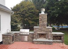 an outdoor brick pizza oven and grill in the back yard