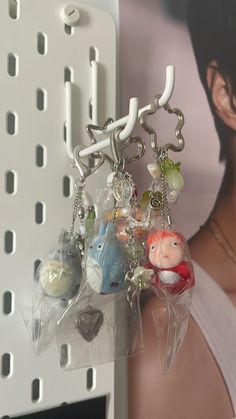 there is a keychain with many charms hanging from it's hooks on the wall