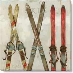 three pairs of skis hanging on a wall