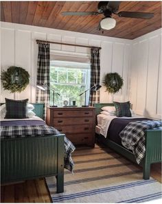 two beds in a room with wooden ceiling and plaid bedding on the covers,