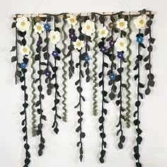 a wall hanging with flowers and leaves on it