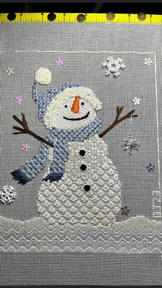 a close up of a snowman on a piece of cloth