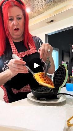 a woman with red hair is eating waffles