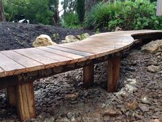 a wooden bench sitting on top of a pile of rocks