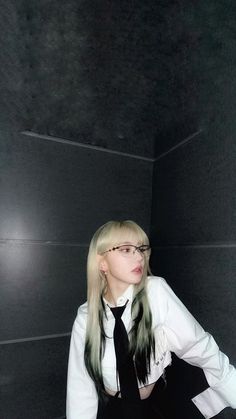 a woman with blonde hair and glasses is wearing a white shirt, black tie and pants