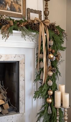 a mantel decorated with pine cones, ornaments and candles in front of a fireplace