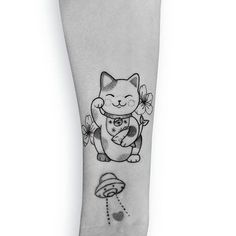 a black and white photo of a cat holding a heart tattoo on the right forearm