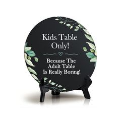 a black plate with green leaves on it that says kids table only because the adult table is really boring