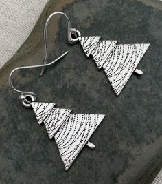 "These are perfectly festive and exquisitely detailed silver Christmas tree earrings. They are understated and classy. The perfect go to holiday earrings. These would make a very festive gift for a friend, loved one or secret Santa. The trees measure 1\" long by 3/4\" wide. They hang from simple silver ear wire hooks. Overall drop length is 1 1/8\". Made from allergy free plated silver. I have a matching necklace in my shop if you would like the whole set. Here is a direct linkhttps://etsy.me/32 Silver Holiday Drop Earrings, Holiday Silver Drop Earrings, Silver Drop Earrings For Holidays, Christmas Silver Jewelry With Matching Earrings, Silver Jewelry With Matching Earrings For Christmas, Nickel-free Sterling Silver Christmas Earrings, Nickel-free Sterling Silver Earrings For Christmas, Handmade Sterling Silver Christmas Earrings, White Sterling Silver Christmas Earrings